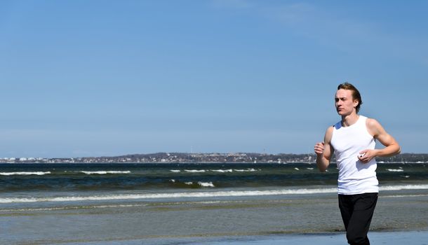 Athletic young male running on the beach