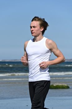 Athletic young male running on the beach