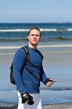 Handsome male tourist lost his way near the ocean