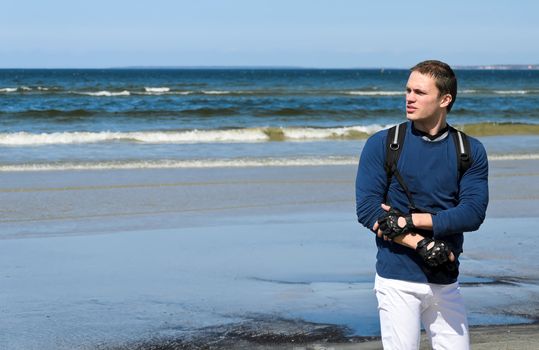 Handsome male tourist lost his way near the ocean