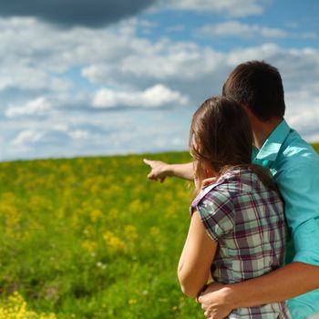 lovers look around on yellow flower field