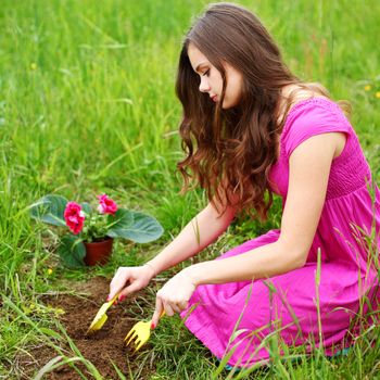girl grow flower on green field