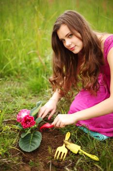 girl grow flower on green field