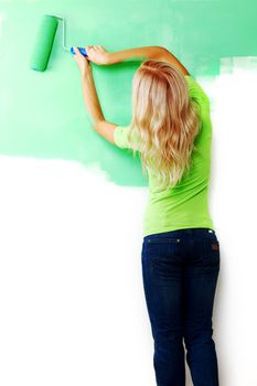 woman paints the wall brush