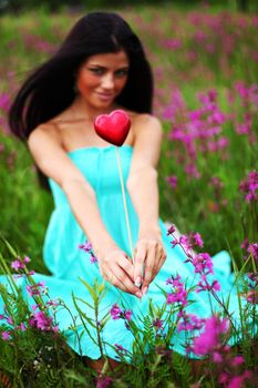 woman on flower field heart in hands