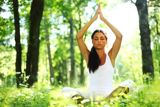 yoga woman on green grass in forest