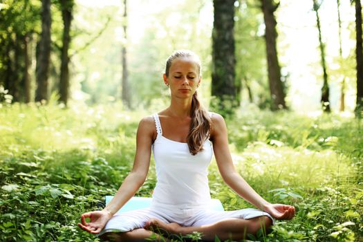 yoga woman on green grass in forest