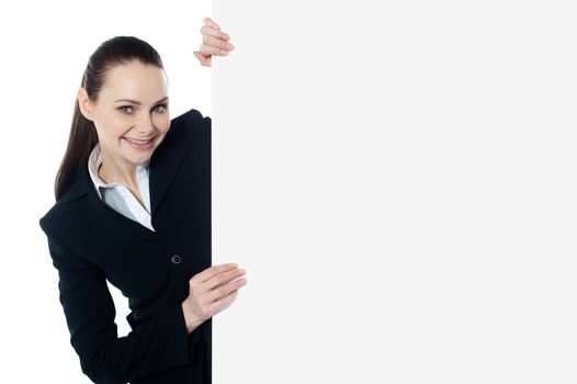 Female executive holding blank whiteboard, smiling at camera