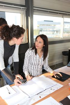 Woman asking her colleague a question