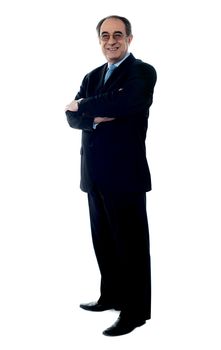 Smiling senior executive posing with folded arms dressed in black suit