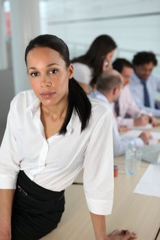 Businesswoman in front of a busy team