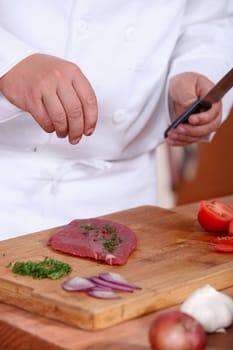 Man putting herbs on a piece of meat