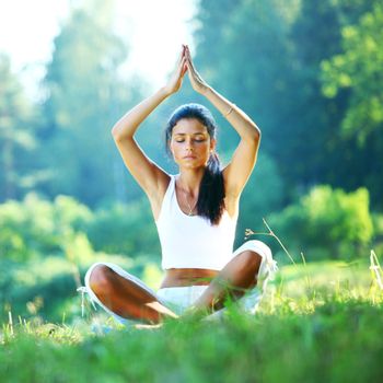  yoga woman on green grass in lotus pose