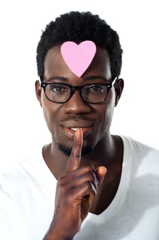 Man with pape heart on forehead gesturing silence, closeup shot