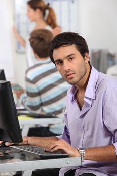 Young man typing at a computer keyboard