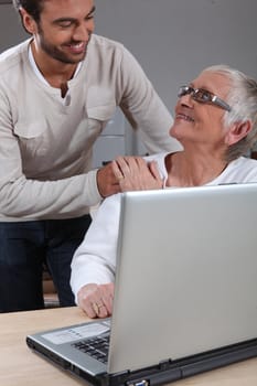 Son helping mother on laptop