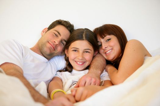 Couple and daughter in bed