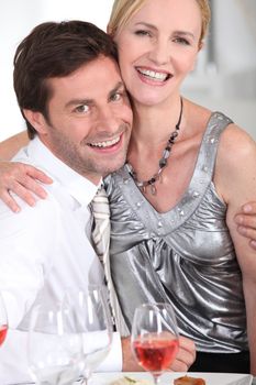 Woman sitting on a man's lap at the dinner table