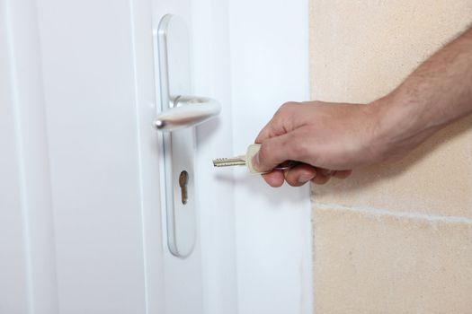 Man putting key in the lock of a door