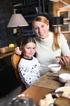 Mother and daughter eating breakfast together