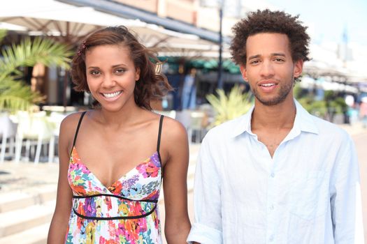 Young couple walking past restaurants in the summer