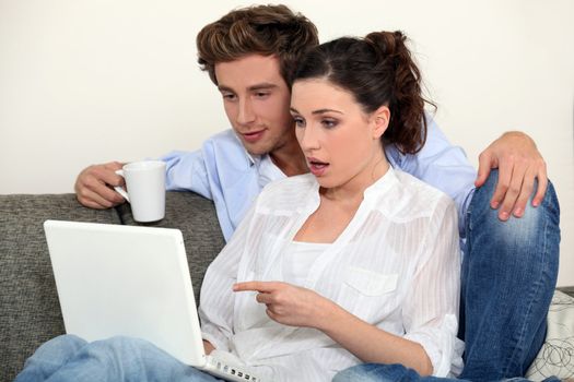 Shocked couple looking at laptop