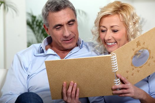 Smiling man and woman watching a photo album