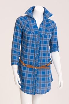 Blue checkered blouse with a brown belt on a mannequin