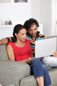 Couple looking at pictures on their laptop