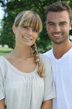 young couple posing together outdoors