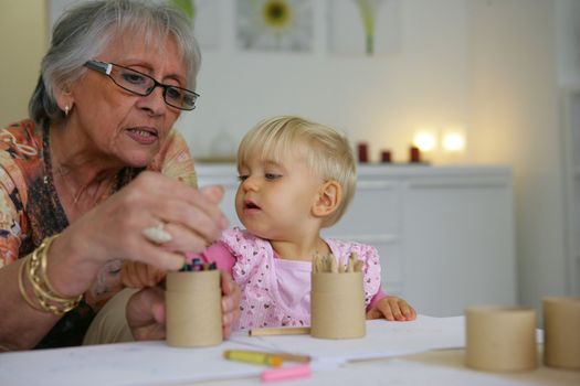 Young child coloring with grandma