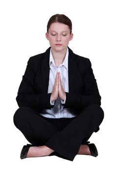 Young businesswoman meditating
