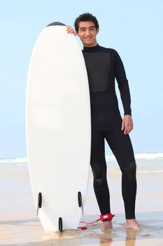 young surfer posing with board