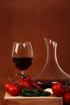 Red wine and glass with red background with vegetales