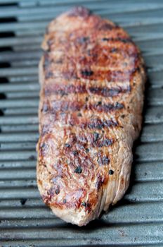 Closeup of succulent Flank steak cooking on the barbecue