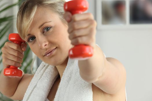 Young woman working out with dumbbells