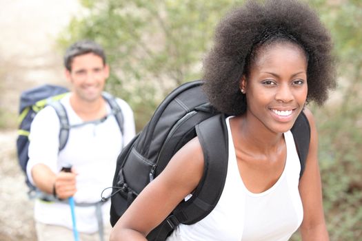 An interracial couple mountain hiking.