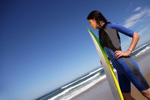 Female surfer stood on beach