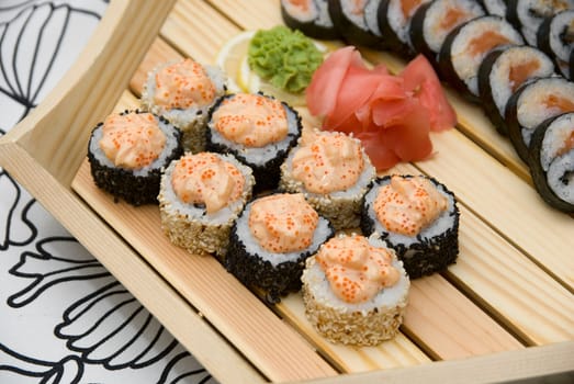 At restaurant: Set of sushi on wood plate.