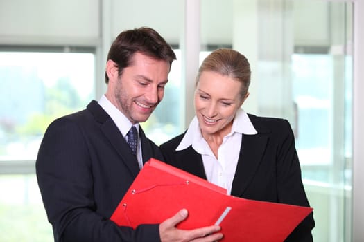 Businessman and woman looking at folder