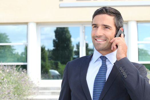 Smiling man in suit talking on cellphone