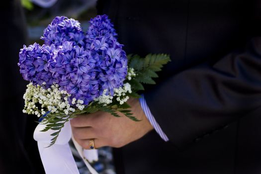 Man hold beautiful colorful wedding flowers in hand