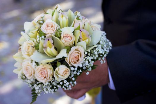 Man hold beautiful colorful wedding flowers in hand