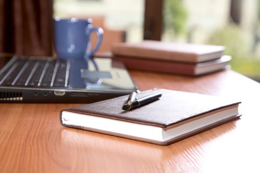 Organizers   pen  laptop a cup on desk