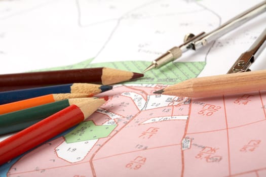 Topographic map of district with a measuring instrument and pencils
