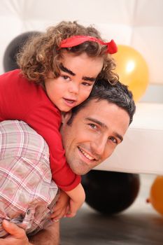 little girl on daddy's back celebrating Halloween