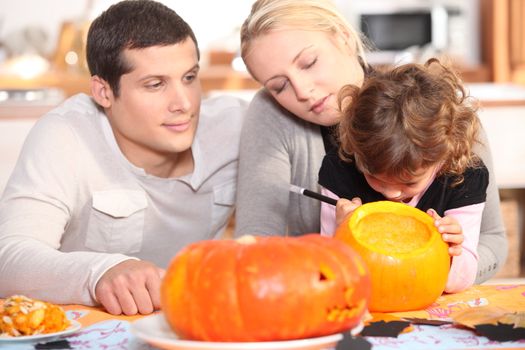 Family preparing pumpkins for Halloween