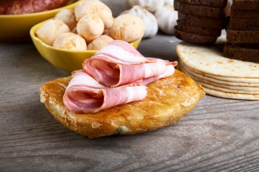 Still-life with  ham and bread on a wooden table