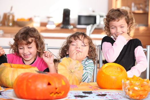 Giggling girls carving pumpkins