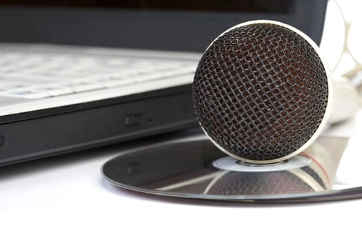 The microphone lays on notebook near to compact discs